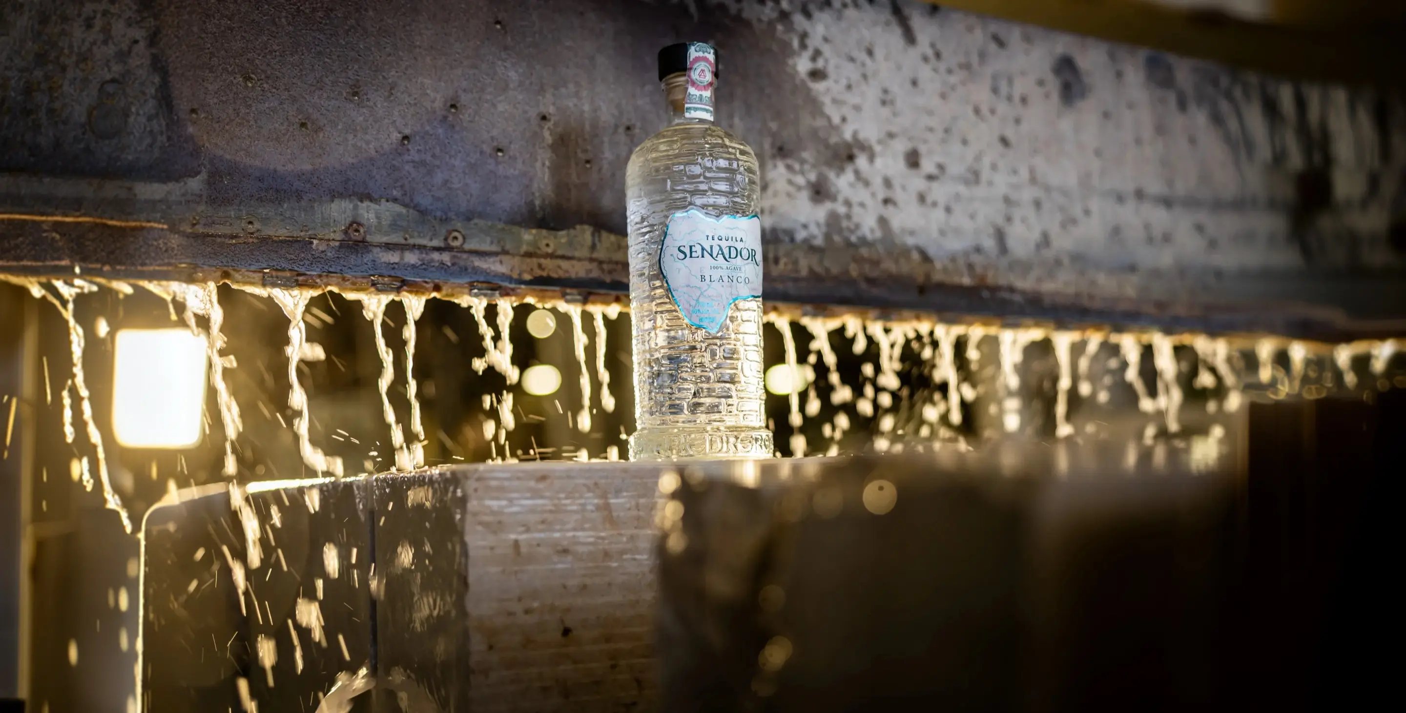 Senador Blanco bottle on a beam over falling sparks